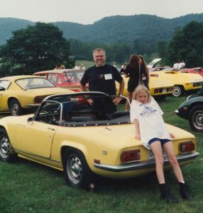 man, young girl and a small yellow car